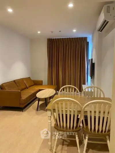 Cozy living room with brown sofa and dining set, perfect for relaxation and entertaining.