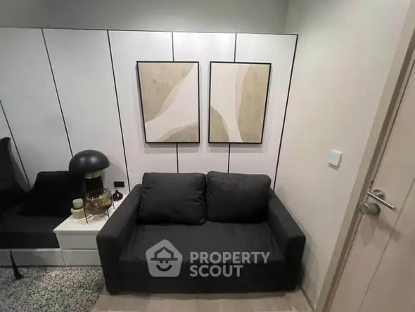 Modern living room with stylish black sofa and abstract art on the wall, perfect for urban living.