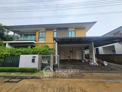 Modern two-story house with spacious driveway and lush greenery