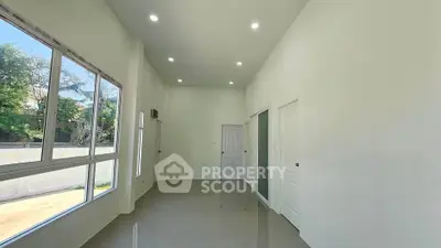 Spacious and bright room with large windows and glossy tiled floor, perfect for modern living.