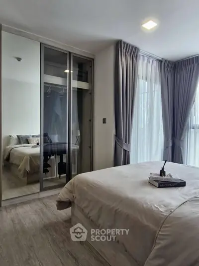 Modern bedroom with mirrored wardrobe and elegant curtains