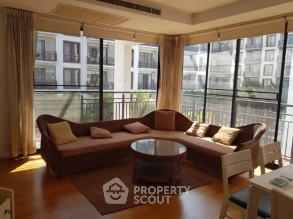 Spacious living room with large windows and cozy seating in modern apartment