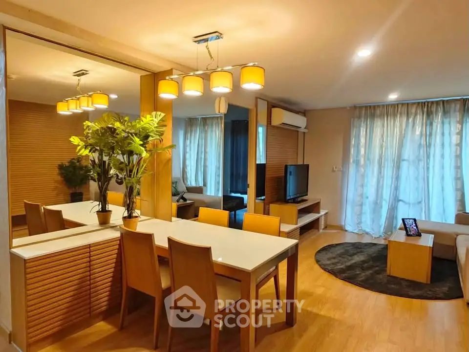 Modern living room with stylish decor, wooden flooring, and ambient lighting in a cozy apartment.