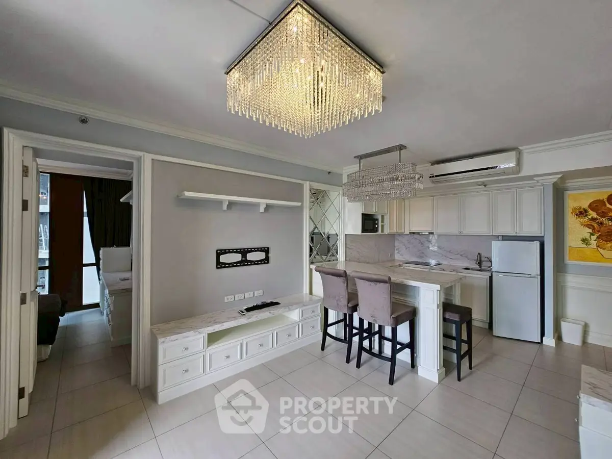 Modern open-layout kitchen with elegant chandelier and sleek appliances