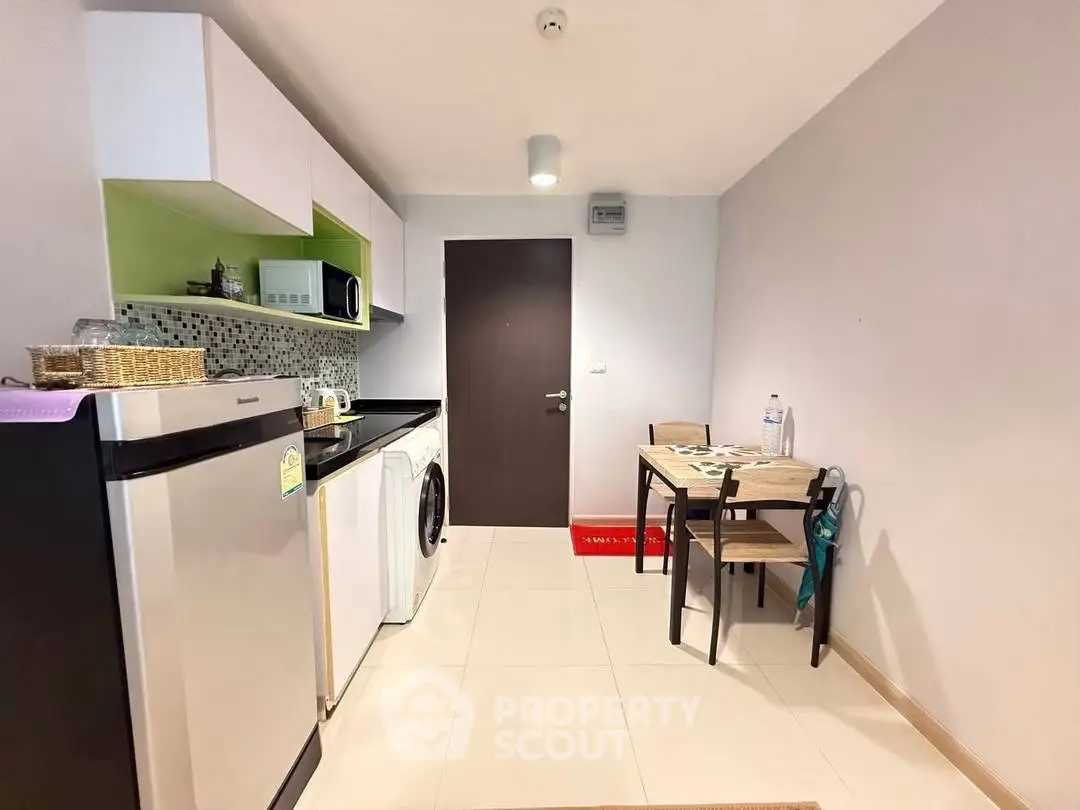 Modern compact kitchen with dining area, featuring sleek appliances and stylish decor.