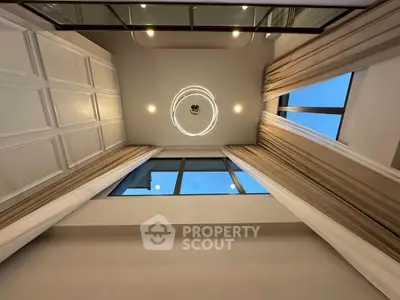 Stunning high-ceiling interior with modern lighting and large windows for natural light.