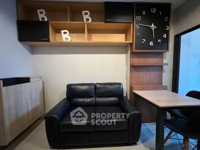 Modern living room with black leather sofa and stylish wall clock