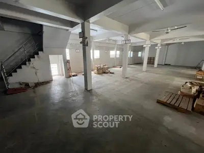 Spacious industrial warehouse with concrete flooring and ample natural light, ideal for storage or manufacturing.