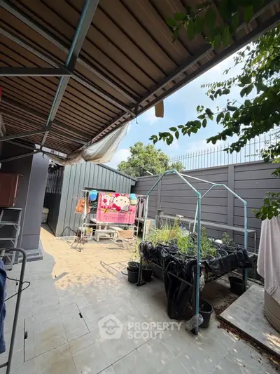 Charming backyard with garden and covered patio, perfect for outdoor relaxation.