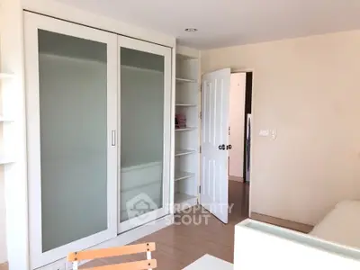 Bright bedroom with sliding door wardrobe and built-in shelves, ideal for modern living.
