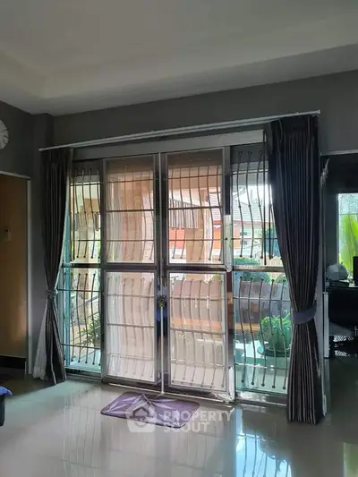 Spacious living room with sliding glass doors and elegant curtains