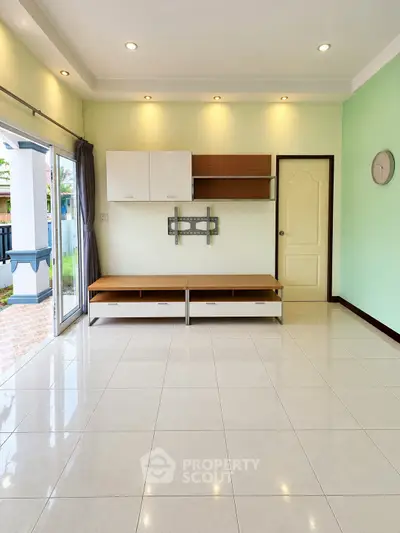 Spacious living room with modern built-in shelves and large windows for natural light.