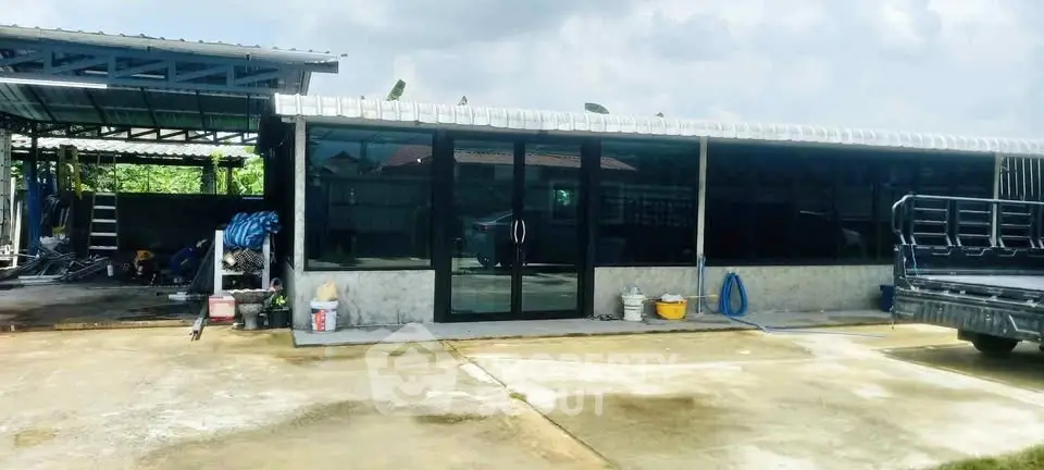 Spacious industrial-style property with large glass doors and ample outdoor space, perfect for commercial use.