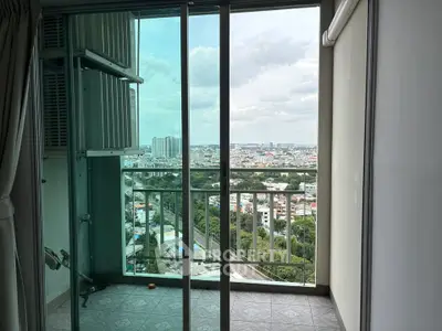 Stunning city view from a modern apartment balcony with glass doors.