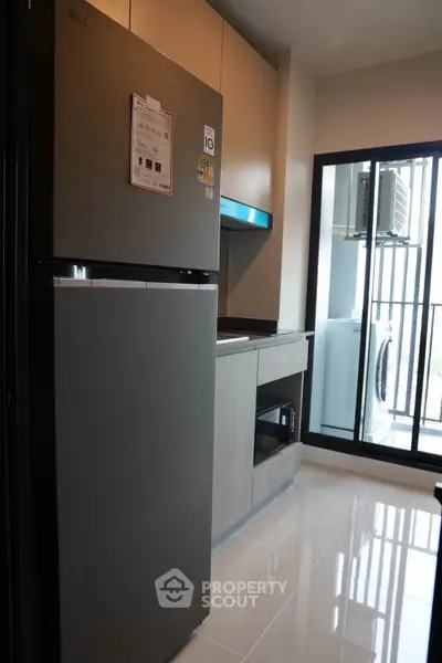 Modern kitchen with sleek appliances and balcony view in a stylish apartment