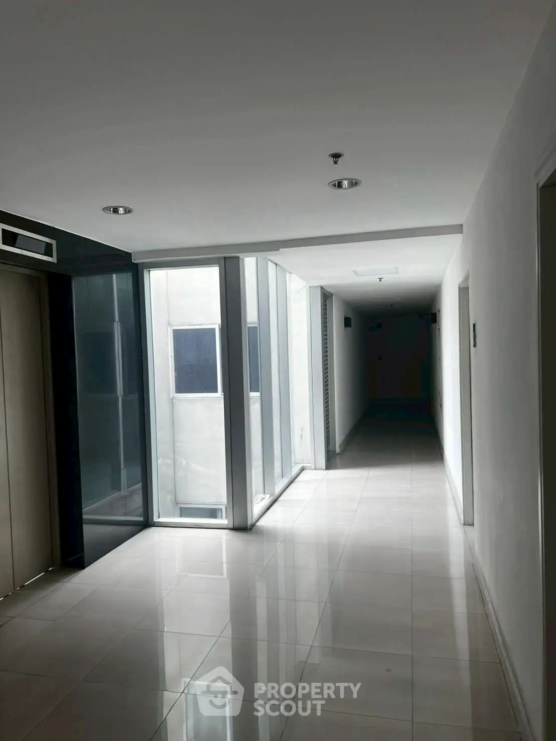 Modern apartment hallway with elevator and natural light
