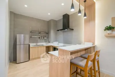 Modern kitchen with sleek design, featuring stainless steel appliances and stylish lighting.