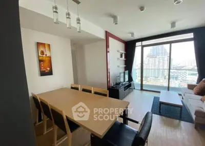 Modern living room with city view, stylish furniture, and ample natural light.