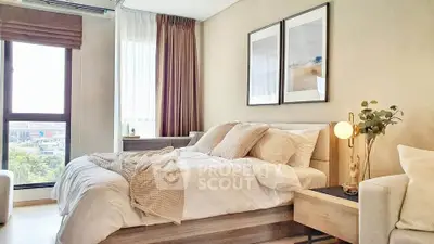 Modern bedroom with cozy decor and large window offering natural light.