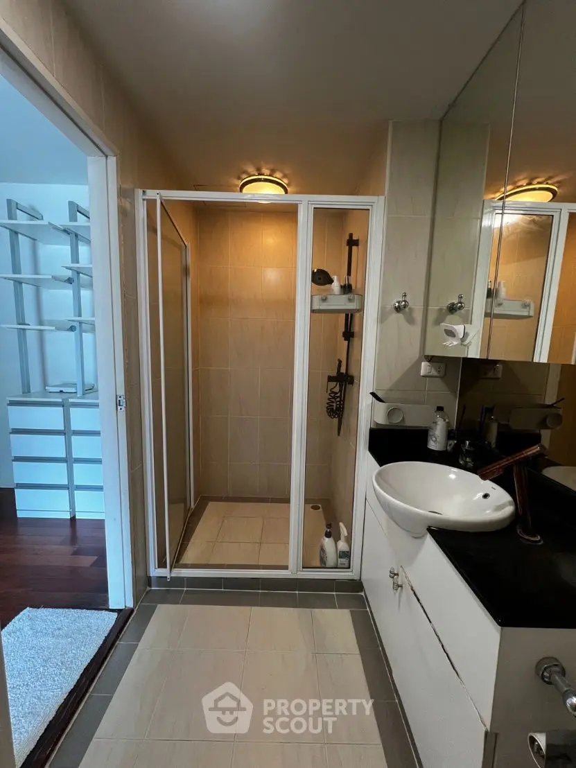 Modern bathroom with glass shower and sleek vanity in contemporary home.
