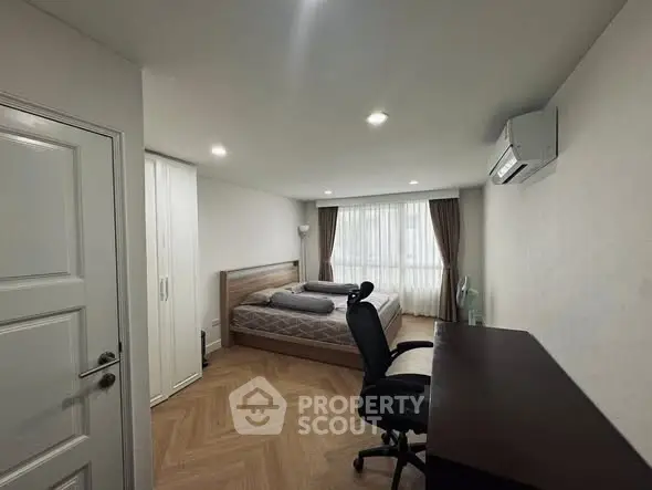 Spacious bedroom with modern furnishings and natural light