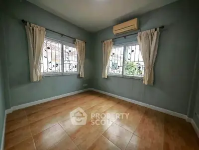 Spacious bedroom with large windows and air conditioning, perfect for natural light and comfort.