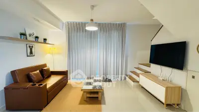 Modern living room with stylish decor, brown leather sofa, and large flat-screen TV, perfect for relaxation.