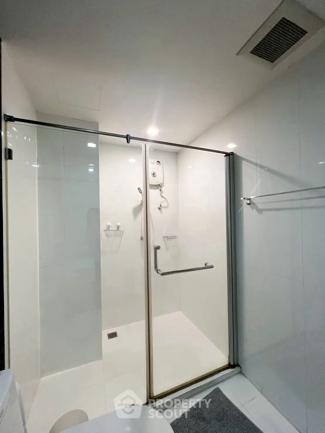 Modern bathroom with glass shower enclosure and sleek white tiles