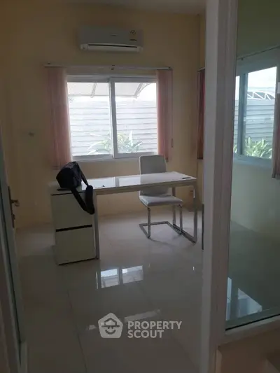 Bright study room with modern desk and chair, large windows for natural light