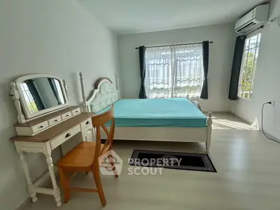 Bright bedroom with vintage furniture and large windows for natural light.