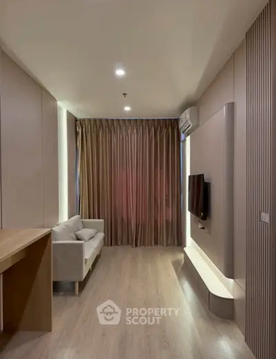 Modern living room with sleek design and cozy sofa, featuring a wall-mounted TV and elegant lighting.