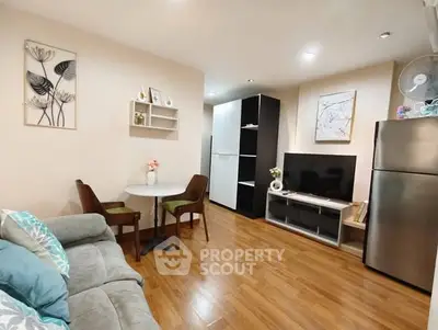 Cozy living room with modern decor and wooden flooring, featuring a compact dining area and sleek entertainment setup.