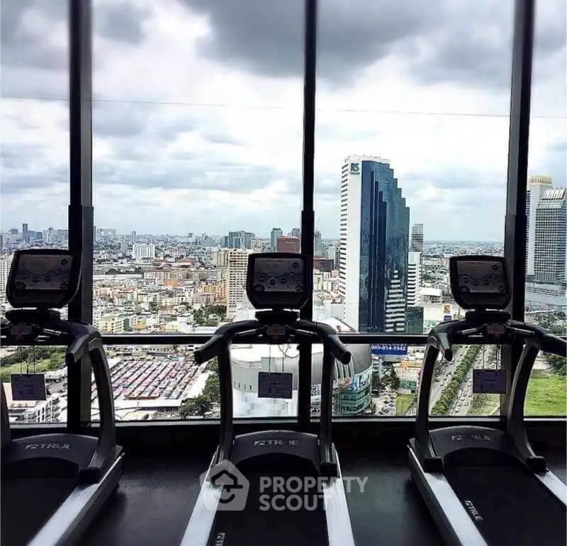Stunning gym with panoramic city views and modern equipment in a high-rise building.