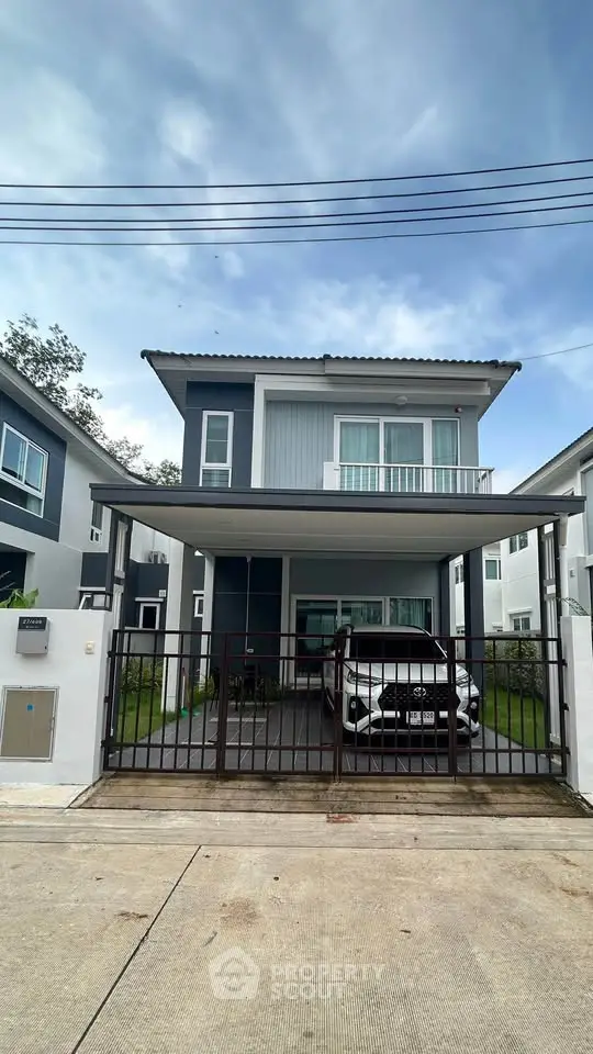 Modern two-story house with carport and sleek design in suburban neighborhood.