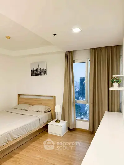 Modern bedroom with city view, minimalist decor, and natural light.