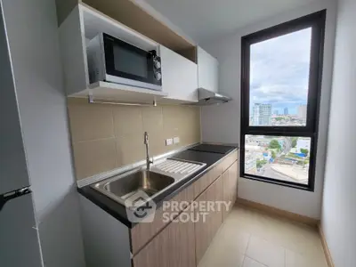 Modern kitchen with microwave and large window offering city views