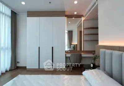 Modern bedroom with sleek design, featuring built-in wardrobe and cozy workspace.