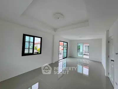 Spacious modern living room with large windows and glossy tiled floors