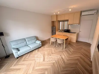 Modern living room with stylish herringbone flooring and cozy dining area.