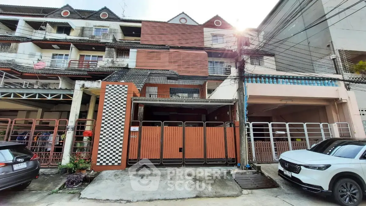 Charming multi-story townhouse with gated entrance and parking space in urban setting.