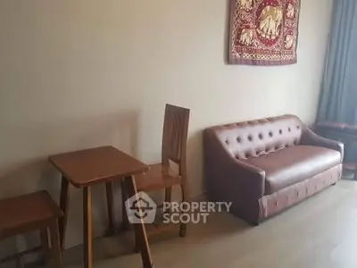 Cozy living room with elegant brown sofa and wooden dining set