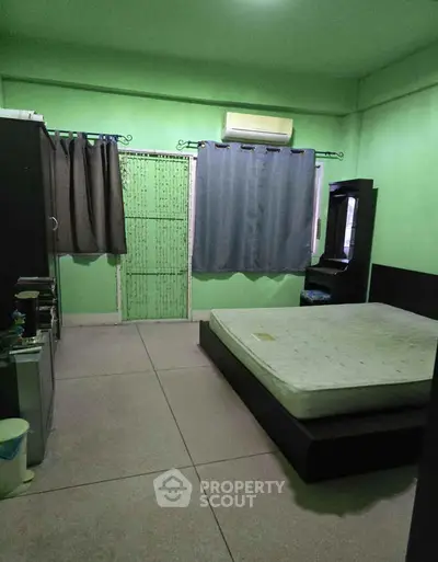 Spacious bedroom with minimalist decor and large windows for natural light.
