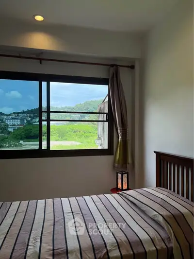 Cozy bedroom with scenic window view in modern apartment