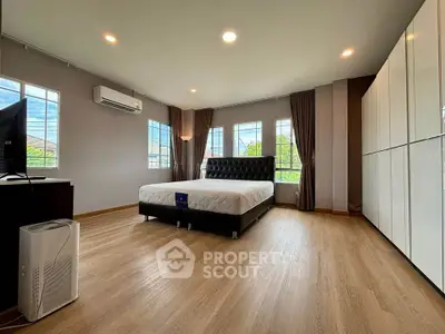 Spacious modern bedroom with large windows and elegant decor