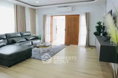 Spacious living room with modern decor and large leather sofa, perfect for relaxation.