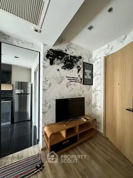 Modern living room with stylish decor and open kitchen view, featuring a sleek TV stand and world map wall art.