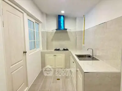 Modern kitchen with sleek design and gas stove in a bright, compact space.