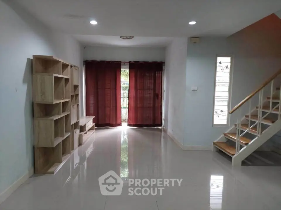 Spacious living room with modern staircase and natural light