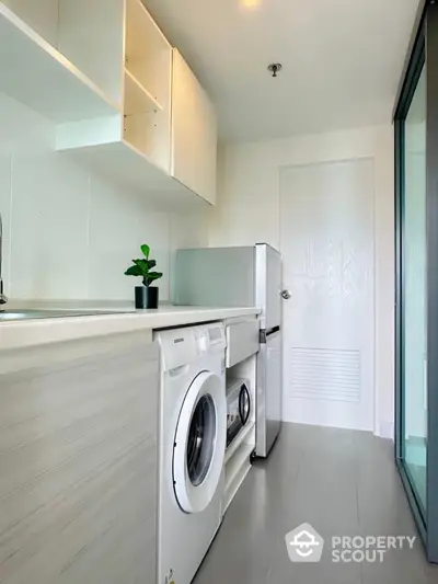 Modern laundry room with washing machine and sleek cabinetry