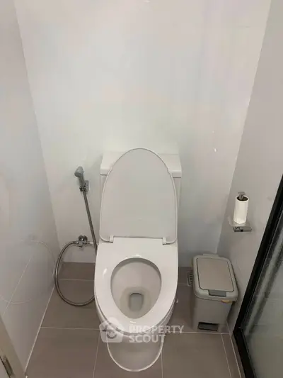 Modern bathroom with sleek toilet and minimalistic design, perfect for contemporary living spaces.